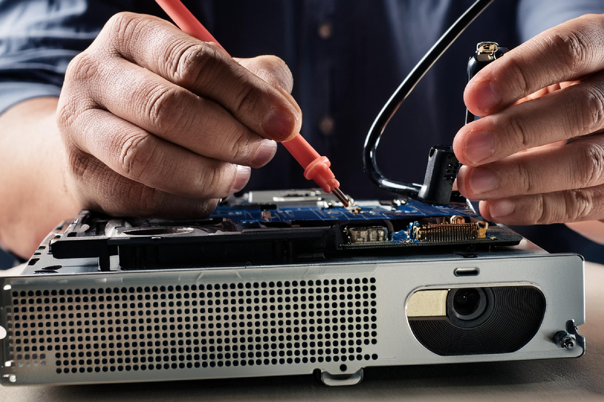 Técnico consertando um projetor em uma oficina.